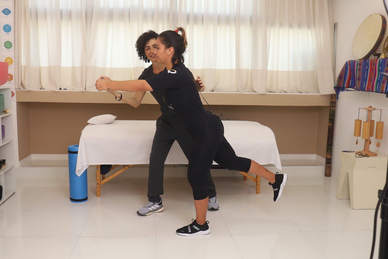 Dra. Alba Comin orientando uma paciente durante atendimento de fisioterapia com EMS em Salvador.